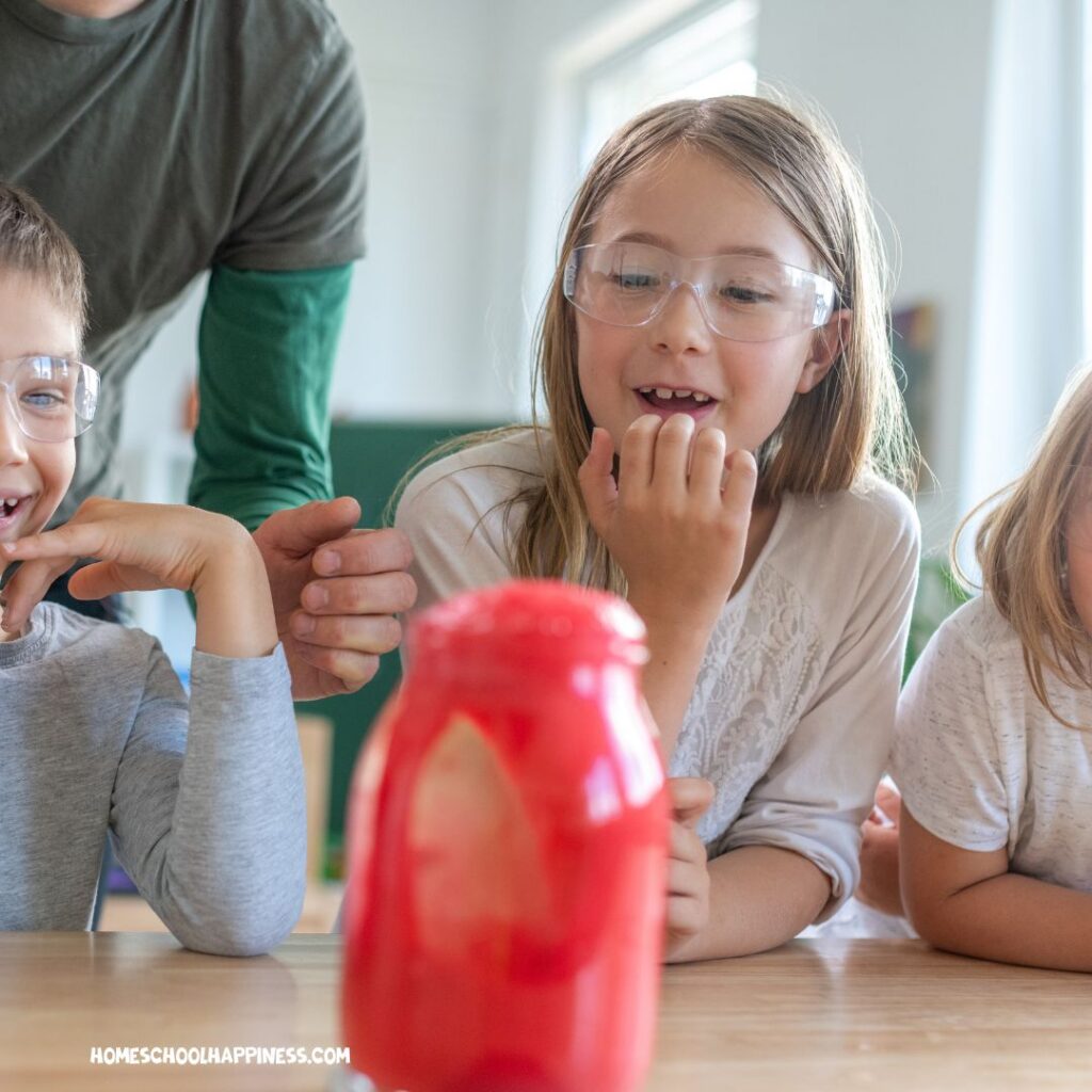 Children watch a science experiment, a hands-on summer activity ideal for kinesthetic learners.